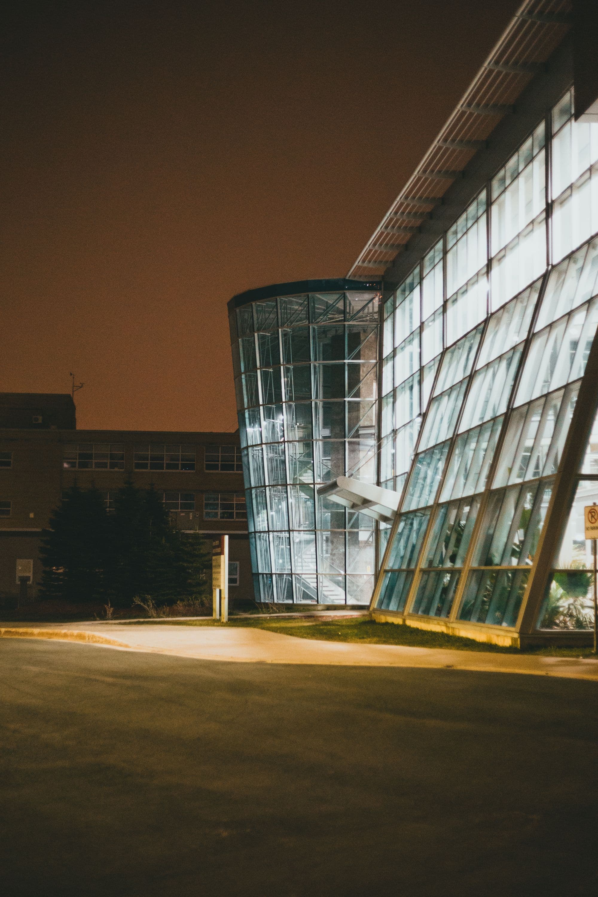 Moderne zorglocatie met verlichte glasgevel in de nacht